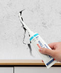 Application of Two Pack Wall Patch Kit With Mending Agent And Spackle, featuring nozzle extender on cracked wall surface.