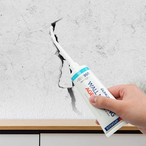 Application of Two Pack Wall Patch Kit With Mending Agent And Spackle, featuring nozzle extender on cracked wall surface.