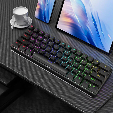RGB mechanical keyboard on a desk with a tablet and cup, showcasing sleek office setup.