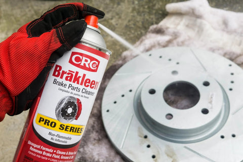 CRC Brakleen brake parts cleaner spray can, Pro Series, 29 oz, non-flammable, held by gloved hand beside a brake rotor.