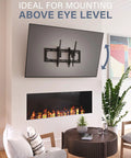 Heavy Duty Tilting TV Wall Mount For Big Screens Up To 90 Inches And 150 Pounds mounted above a modern fireplace in a living room.