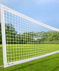 Heavy Duty Volleyball Net For Backyard And Pool Play, 32x3 Feet With 4 Inch Mesh, installed in a garden setting.
