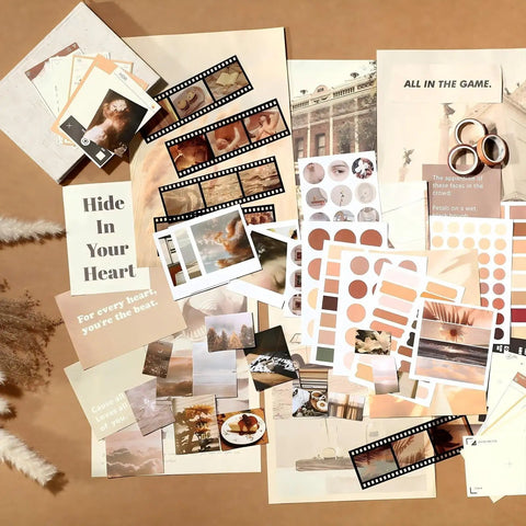 Complete Scrapbook Kit With 114 Pieces Aesthetic Supplies for Junk Journaling including posters, stickers, and paper on a table.