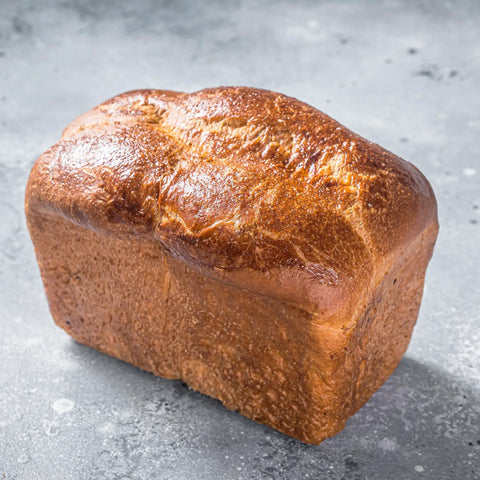 Golden brown loaf of bread displaying rising effects of Double Acting Baking Powder In A Resealable Bucket For Cookies Cakes Muffins