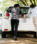 Two people inspecting a car with a Stainless Steel License Plate Backing Twin Pack 12 By 6 Inches Silver Car Tag Holder installed.