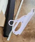 Portable Cordless Electric Fabric Scissors For Sewing, Tailoring & Leather Cutting on a wooden table with fabric.