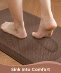 Feet stepping on Anti Fatigue Kitchen Floor Mat 20 By 32 Inches Three Quarter Inch Thick Cushioned Ergonomic Standing Pad Waterproof Surface Non Slip Bottom For Home Office Sink Brown on wooden floor.