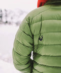 Person wearing a green puffer jacket outdoors, showcasing the jacket's material suitable for Tenacious Tape Repair Patches