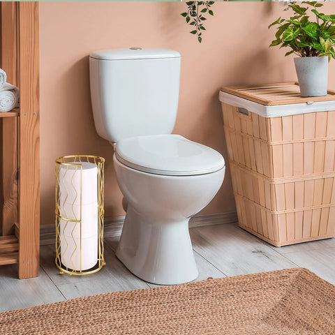 Gold Finish Standing Toilet Paper Holder With Three Roll Reserve next to toilet in bathroom setting