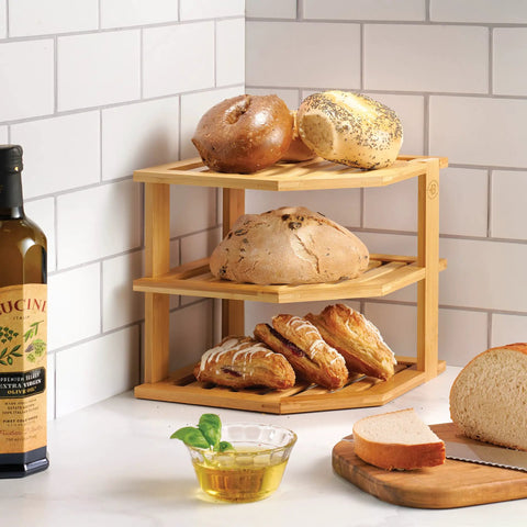 Total Kitchen Game Changer, Super Handy Bamboo Corner Shelf, 3 Tier Plate Rack holding bagels and bread, natural bamboo material.