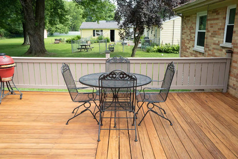 View of outdoor deck with table and chairs, showcasing Heavy Duty Water Based Deck Stain And Sealer In One Semi Transparent Wood Finish For Outdoor Decks.