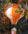 Hot Air Balloon Paper Lantern Decor Set Of 6 With Striped Blue Green Pink Orange Yellow Patterns 12 Inch Diameter And 16 Inch Expanded Height Perfect For Weddings Birthday Engagements Christmas Party Decor Party Ready Vibe. Large orange and white striped paper lantern resembling a hot air balloon hanging among trees.