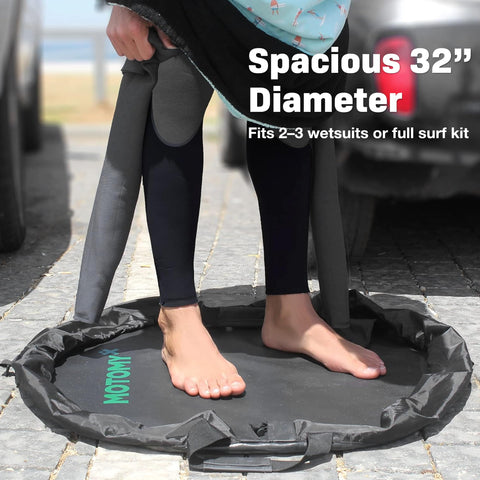 Person using Wetsuit Changing Mat And 2 In 1 Gear Bag With 5000X Waterproof Tech, 32-inch diameter, on a paved surface