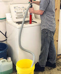 Person using Siphon King 24 Inch Hand Transfer Pump With 36 Inch Hose to transfer water into bucket from washing machine.