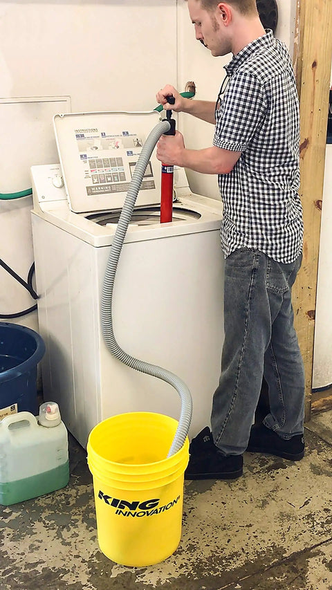 Person using Siphon King 24 Inch Hand Transfer Pump With 36 Inch Hose to transfer water into bucket from washing machine.