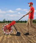 Person using Easy To Use Manual Seed Planter With Hand Push Roller Seeder For The Garden, No Fuss 10-Port Seed Dispenser