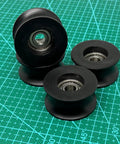4 Pack Black 8x40x20mm U Groove Pulleys With PA Coated Nylon Bearings And Stainless Steel S608Z Bearings Durable Plastic Roller Wheel Set For Small Belt Drive Systems, shown on cutting mat