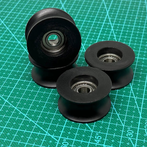 4 Pack Black 8x40x20mm U Groove Pulleys With PA Coated Nylon Bearings And Stainless Steel S608Z Bearings Durable Plastic Roller Wheel Set For Small Belt Drive Systems, shown on cutting mat