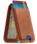 Top Shelf Genuine Leather MagSafe Wallet With Integrated Stand Holds Six Credit Cards Securely Showcased In Smooth Brown Oil Waxed Cowhide displaying cards and cash.
