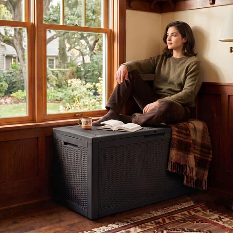 Heavy Duty 160 Gallon Deck Box Crafted From Weatherproof Resin With Secure Locking Lid used as a coffee table by a window.