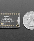 12 Key Capacitive Touch Sensor Breakout Board With MPR121 IC next to a quarter for size comparison.