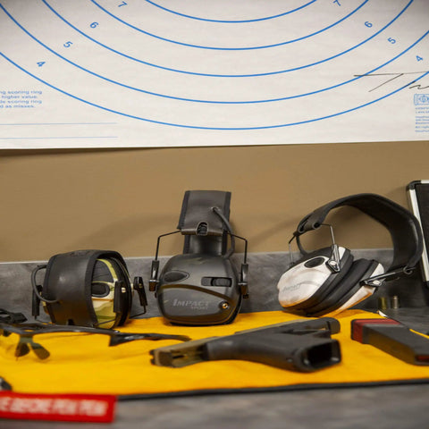 Impact Sport Electronic Shooting Earmuff With Sound Amplification In Multicam Alpine on a shooting range table