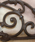 Close-up of a Heavy Duty Victorian Corner Shelf Bracket showing intricate swirl design in solid cast iron rustic brown finish.