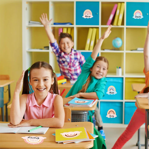 Colorful classroom with kids using 192 Piece Boho Rainbow Name Tags Self Adhesive Labels on desks for decoration and activities.