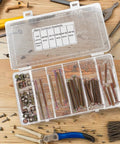 49 Piece M6 Hex Drive Screws And Barrel Nuts Set For Bed Frame Assembly And Home Repairs in clear storage box on workbench.