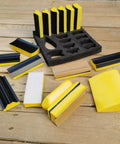 16-piece contoured sanding block set with yellow/black hook-and-loop foam blocks and rack
