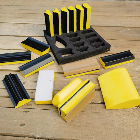 16-piece contoured sanding block set with yellow/black hook-and-loop foam blocks and rack