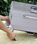 Stainless Steel Portable Tabletop Gas Grill With 10000 BTU Power, 285 Square Inches Of Cooking Space being set up on table