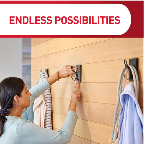 Person hanging clothes on XL Matte Black Triple Hook With Three Adhesive Strips For Damage Free Wall Hanging No Tools Needed.
