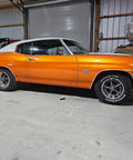 Showroom Smooth Dreamsicle Orange Basecoat Paint Gallon Ready To Spray Mix With Slow Reducer For Zero Hassle Street Car Restorations And Bumper To Bumper Shine on a classic muscle car in a garage.