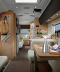 Interior view of a motorhome with a Lanterna Lux Satin Nickel LED Touch Lamp Two Pack on the dining table, beach view outside.