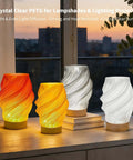 Crystal Clear PETG Filament 1.75mm 1kg for 3D printing in colorful lampshades on a window sill with city view.
