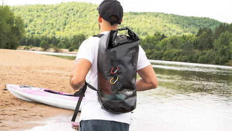 ExoDry 30L Large Drybag With Roll Top Closure Waterproof 500D PVC on man kayaking by river, showing backpack style straps, black