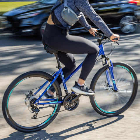 Cyclist riding All-Terrain Go-To Hybrid Bike With 700c Wheels 21-Speed Gearing Aluminum Frame Suspension Fork on city street