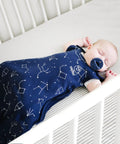 Baby in crib wearing Ultimate Baby Sleep Sack For 4 Season Merino Wool Sleeping Bag With Organic Cotton Outer Night Sky