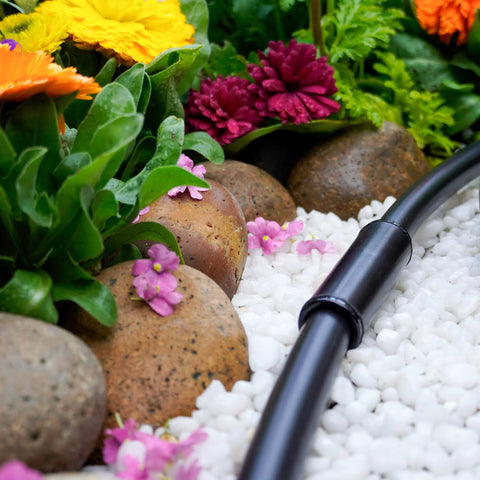 1/2-inch compression drip irrigation tubing with coupling on white decorative gravel