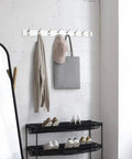 Wall Mounted Coat Rack With Eight Hooks Wood Base Modern White Entryway And Bedroom Organizer For Coats Scarves Towels Leashes And More Space Saving Durable Metal Hooks installed in a room with items hanging.