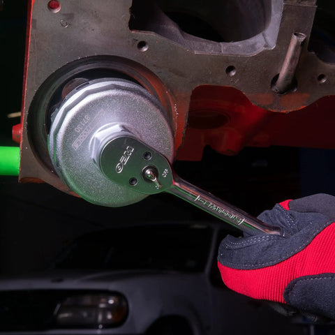 Toyota And Lexus 64mm Oil Filter Wrench with 14 Flutes in use on engine, showing fit on filter housing.