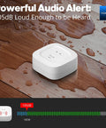 Smart Water Leak Detector 4 With 105dB Alarm, shown on wet wooden surface, highlighting powerful audio alert feature.