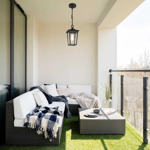 Straight Up Farmhouse Outdoor Pendant Light With Clear Glass Shade And Rust Proof Metal Frame Killing It As A Heavy Duty Hanging Lantern Top Shelf Pick For Porches Entryways And Gazebos In Sleek Matte Black illuminating a balcony seating area.