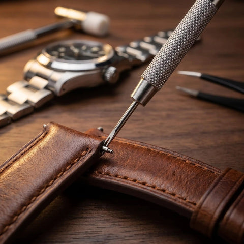 53 Piece Watch Band Tool Kit With Link Remover Pro Grade Spring Bar Tools used on a brown leather watch strap on a wooden table