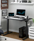 FLEXISPOT Electric Standing Desk With 40x24 Seamless One-Piece Black Desktop featuring dual monitors and laptop in home office setting.