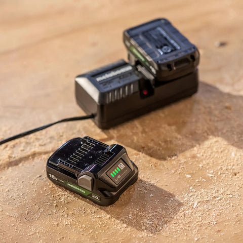 18V battery and charger on a wooden surface for a cordless 5-inch random orbital sander with top notch dust collection, ultra lightweight finish tool