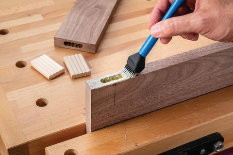Applying glue to wood joint using Silicone Glue Brush Set For Beadlock Tenons Ribbed Tenon Shaped Applicators on a workbench