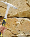 Hand holding 2 Pack 30oz Dual Head Weeding Mattock Hoe With Pointed Tip And Flat Head For Digging Mining Rock Breaking Soil Leveling
