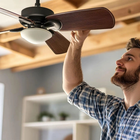 Man adjusting the ceiling fan, showcasing the style of Twenty Piece Heavy Duty Ceiling Fan Blade Screws Quarter Twenty Thread By Three Eighth Inch Long Carbon Steel Pan Head Bolts Copper Finish Locks Right In Zero Wobble Residential Gear.